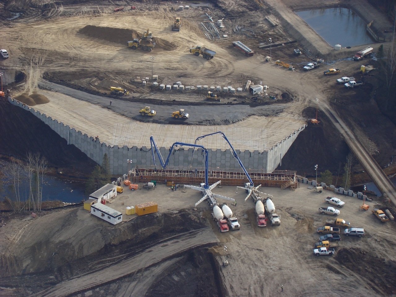 A construction site with trucks and cranes in the foreground.